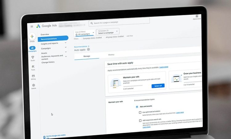 Laptop screen showing a Google Ads dashboard with the Recommendations tab open and navigation on the left, displaying campaign options and auto-apply settings.